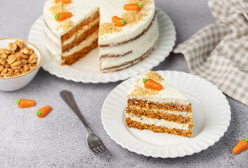 Homemade carrot cake made with walnuts, iced with cream cheese. Sweet dessert.