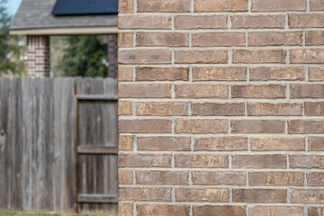 Red brick wall with fence in background