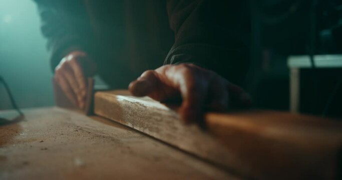 Sanding down the surface of a wooden plank to get it ready for painting
