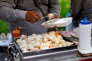 Indonesian street food dimsum or siomay, and illustration of hand putting siomay or dimsum into styrofoam container or box
