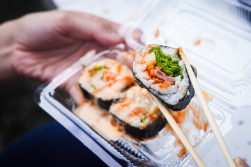 Indonesian street food sushi, illustration of hand holding sushi with chopsticks
