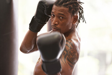 Fitness, portrait and black man with boxing gloves in gym for challenge, fight and competition training. Power, muscle and serious face of champion boxer at workout with confidence in sports club. - obrazy, fototapety, plakaty