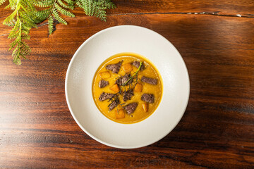 Cream of sirloin steak in a hotel restaurant. Meal on wooden table. Delicious soup.Thick sirloin soup in a hotel restaurant. Meal on wooden table. Delicious soup with spices.