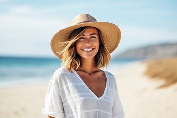 Portrait of happy young woman in hat on the beach, smiling
