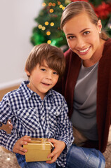 Child, mother and portrait with Christmas present for festive season celebration for bonding, giving or holiday. Female person, boy and gift box in Canada at tree for vacation, happiness or package