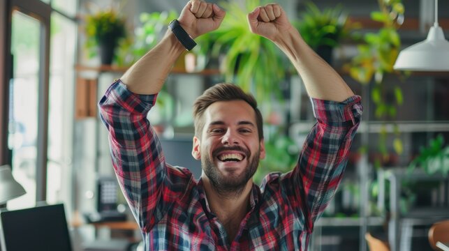 Man Laughing While Working on Laptop in Cozy Office Space