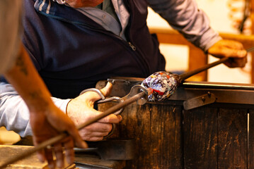 Glass Master at work in Murano island Venice Italy creates a drink glass