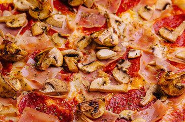 pizza with ham, salami and mushrooms close up