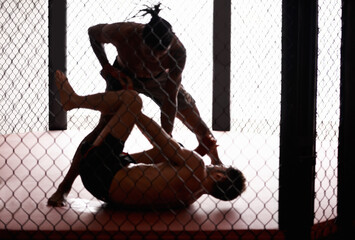 Cage, fight and men sparring for competition, challenge and fitness in mixed martial arts action....