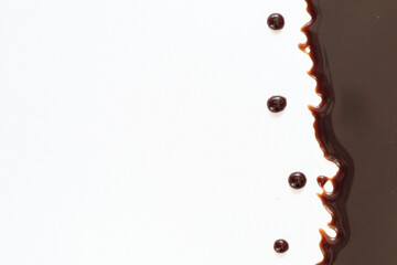 Melted dark or milk chocolate over cake isolated on white