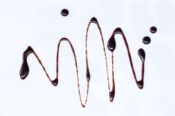 Chocolate syrup drizzle isolated on white background. A splash of sweet chocolate sauce.