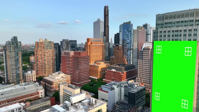 Green screen billboard with tracking markers in downtown New York City. Modern American urban metropolis with new, tall skyscrapers. Aerial orbit for animation.