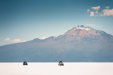 Off-road cars driving on Salar de Uyuni salt flat in Bolivia.