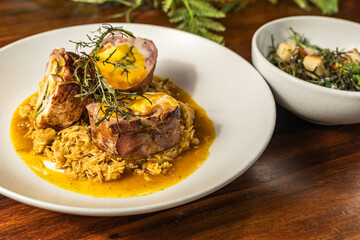 Exquisite medallions on a base of orange rice with salad. Delicious hotel restaurant food.