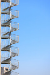 高層アパートの螺旋階段、青空背景