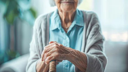 Fotobehang Oude deur Close-up of an elderly person's hands clasping a wooden cane, symbolizing aging and support.