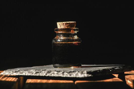 Magic potion bottle on the old wooden table background front view. Witchcraft concept.
