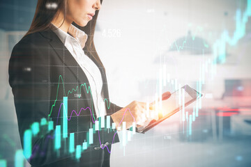 Businesswoman hands using tablet with growing forex chart on blurry office interior background. Financial investment and economy concept. Double exposure.