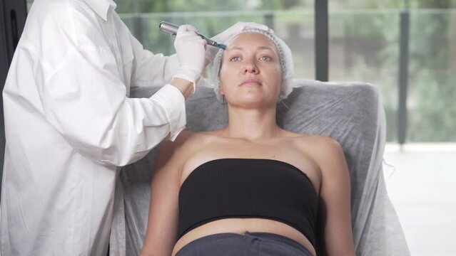 Close-up, a woman at the reception of a cosmetologist, doing a procedure for facial rejuvenation