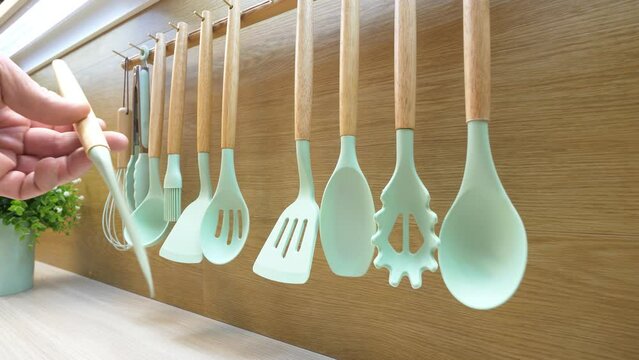 Kitchen utensils for cooking. Man's hand takes a kitchen flexible spatula