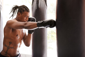 Muscle, punching bag and black man in gym for exercise, boxing challenge or competition training. Power, fitness and serious champion boxer at workout with confidence, fight and energy in sports club - obrazy, fototapety, plakaty