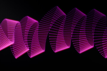 Pink and purple neon curved wave of light as curls or swirl with dotted stripes on black background. Abstract background with motion light effect, light painting in New Year style.