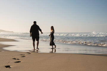 Silueta de pareja dando un paseo por la playa de El Cofete, Fuerteventura - obrazy, fototapety, plakaty