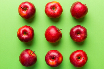 Many red apples on colored background, top view. Autumn pattern with fresh apple above view