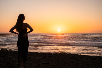 chica mirando puesta del sol en la playa de Fuerteventura
