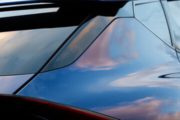Car panels with reflections of a blue and cloudy sky. Pastel colors pinks and blues