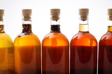 Many bottles with brown transparent alcoholic drink. Homemade tinctures based on natural herbs....