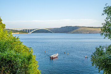 View of Tito's bridge from Kraljevica in summer with a boat in foreground, Croatia