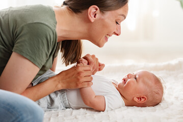 Happy mature mother playing with his cute baby son (3 months old)
