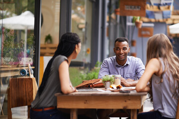 Friends, relax with people at coffee shop and conversation for bonding, diversity and trust outdoor...