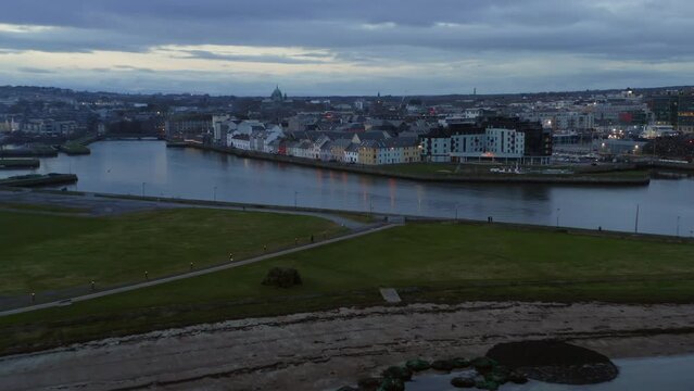 Picturesque aerial dolly at twilight featuring Galway iconic spots: Long walk, Claddagh, Corrib river. 