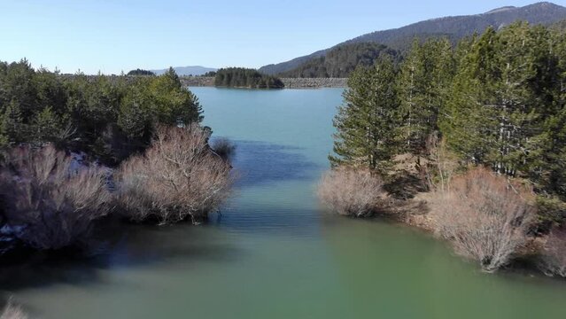 Fast drone passing between two lake inlets sunny day