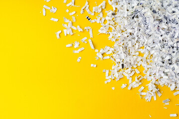 Shredded white paper on light yellow background