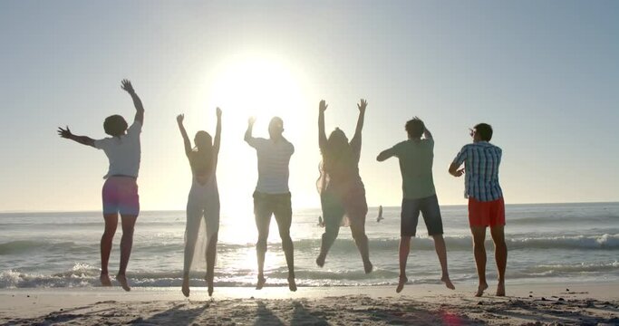 Diverse group of friends jump in joy on a sunny beach