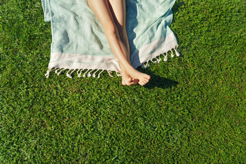  Child feet on green grass, barefoot little girl on meadow. Sunbathing on the green grass -...