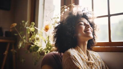 Fototapeta premium A happy Charming laughing woman is sitting on the couch and relaxing at home. Lifestyle, Weekends, Relaxation concepts.