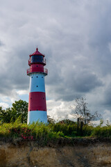 Fototapeta na wymiar Lighthouse on the Baltic Sea with an overcast sky.