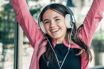 euphoric girl teenager with headphones on the street
