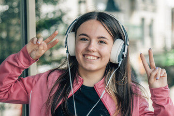 fun girl teenager with headphones on the street