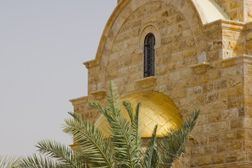 Fragment of wall with golden dome above entrance to modern Orthodox Church of John Baptist. Al-Makhtas is historical place of Epiphany near site of baptism of Jesus Christ in Jordan.