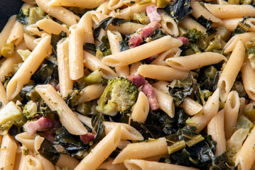 Deliziose penne lisce condite con broccoli e pancetta, pasta italiana, cibo europeo 