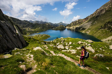 Fototapeta premium Young hiker girl summit to Ratera Peak in Aiguestortes and Sant Maurici National Park, Spain