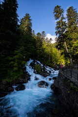 Summer and young girl in Uelhs Deth Joeu waterfall, Val D Aran, Spain