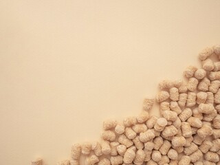Extruded bran scattered on a beige background with space for text. The concept of proper snacking,...