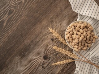 Extruded bran in a white dish with a towel and wheat ears on a wooden table. The concept of proper...