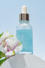 Aestethic image with abstract cosmetic product, serum, oil y etc. Glass dropper bottle with pipette and label on white podium with alstromeria flowers